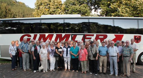 Die Reisegruppe steht vor dem Reisebus zum Gruppenfoto.